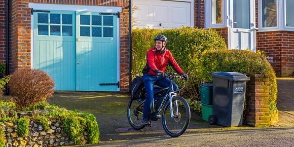 A cyclist on his bike in the front garden