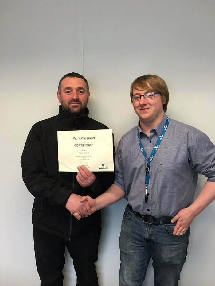 Student Ryan Bowie receives his work placement certificate from AECC Senior Site Manager Gerry Goldie