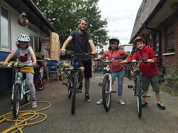 A Man and 3 children on their bikes.