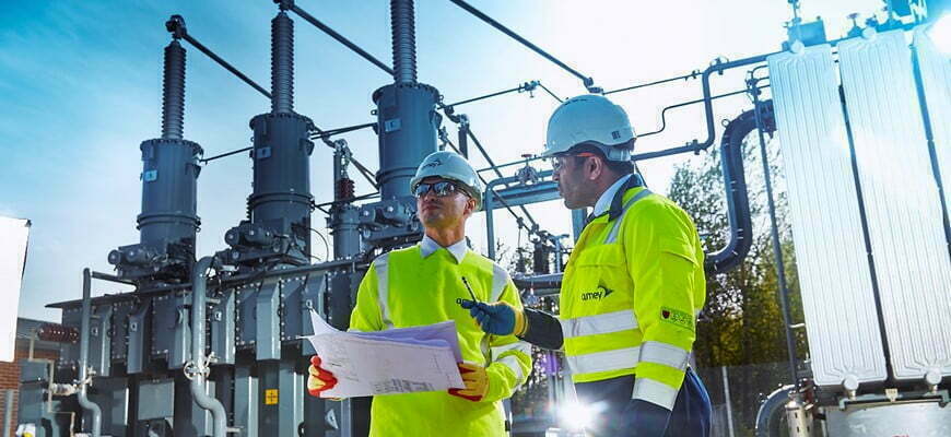 2 Amey employees outside a powerplant