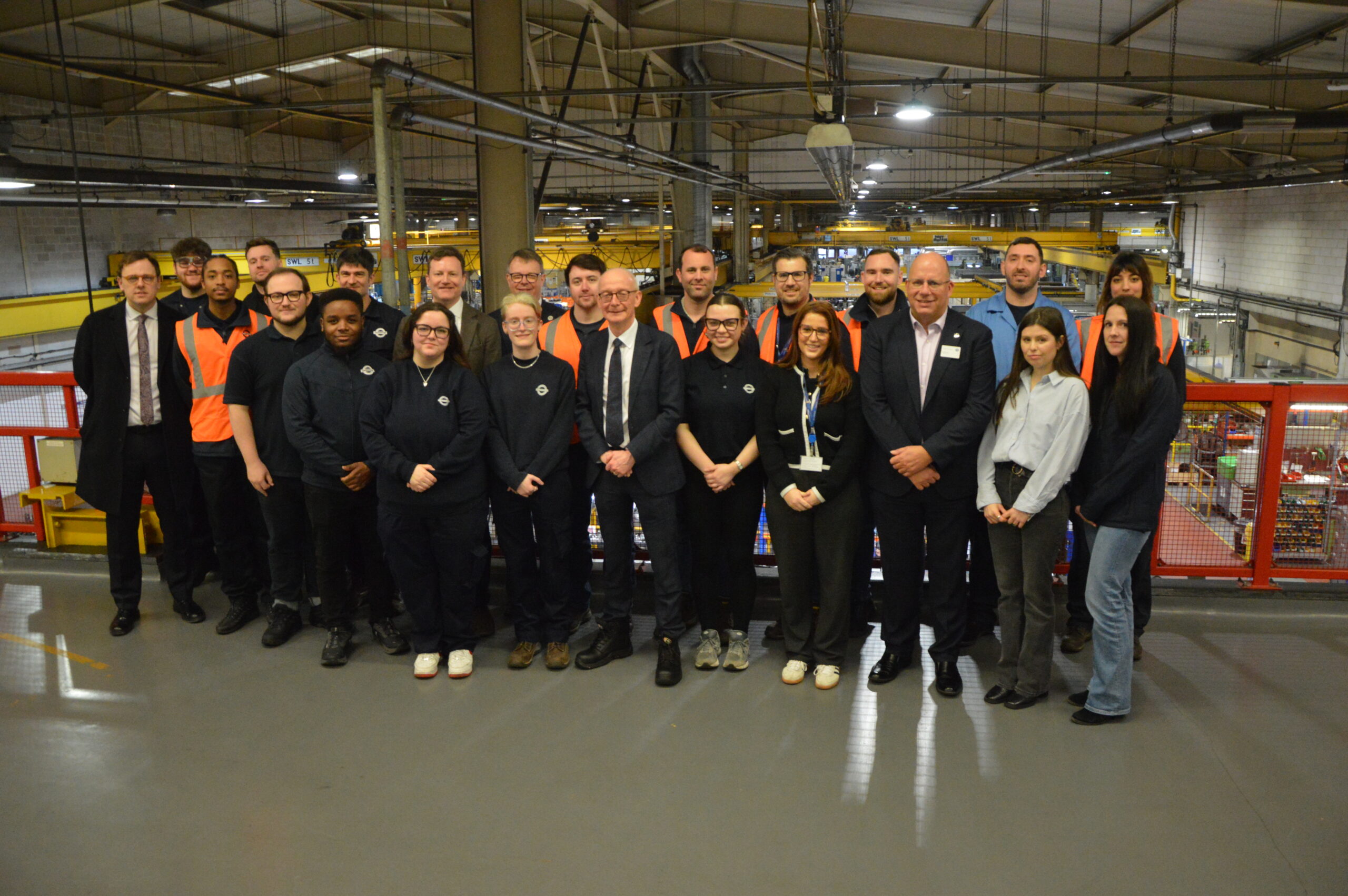 DWP Image - Pat McFadden MP, Secretary of State for Work and Pensions, Andy Lord, TfL Commissioner and TfL apprentices at Acton Works