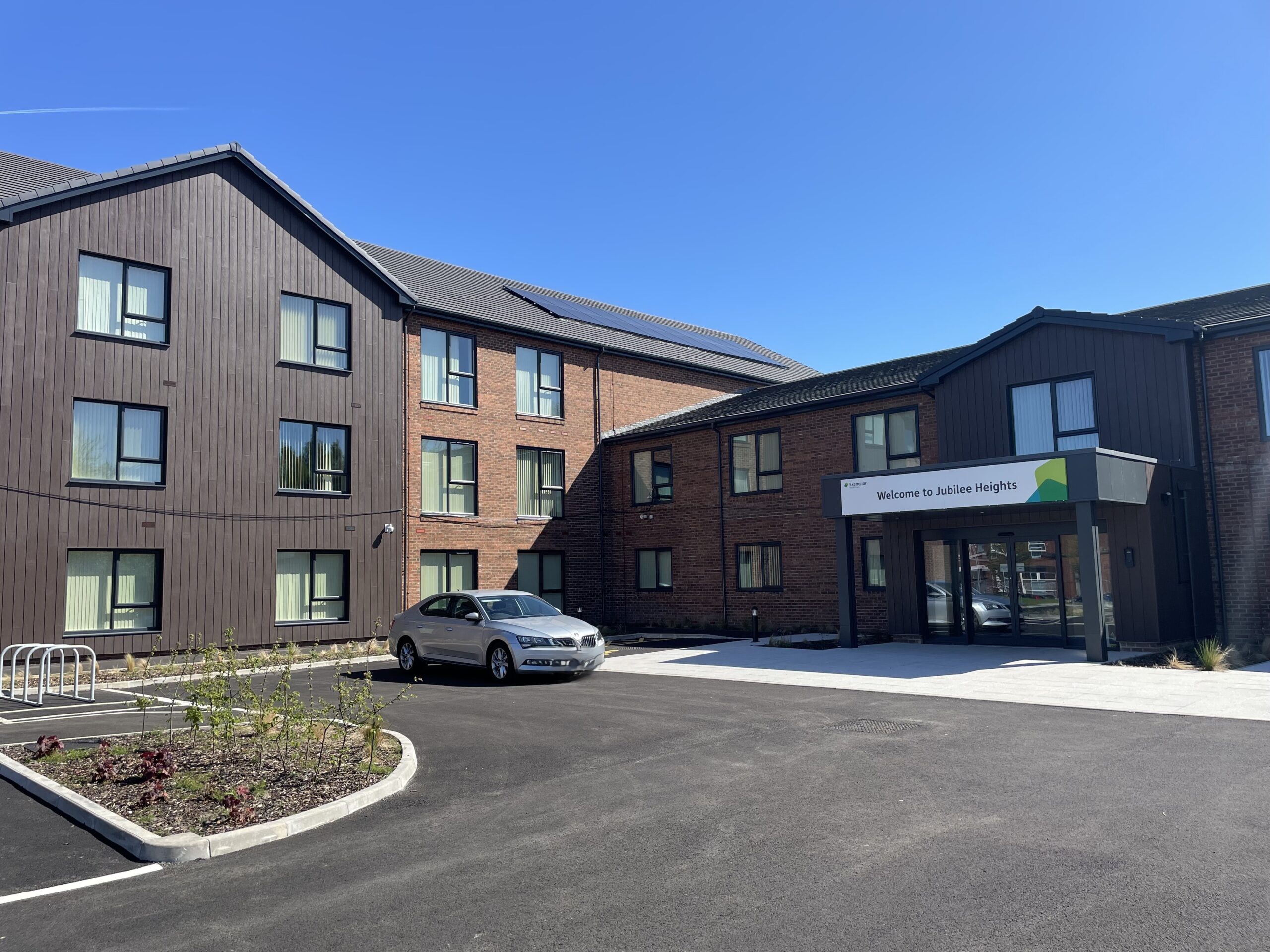 A close up shot of the care home building with one silver car parked in the car park