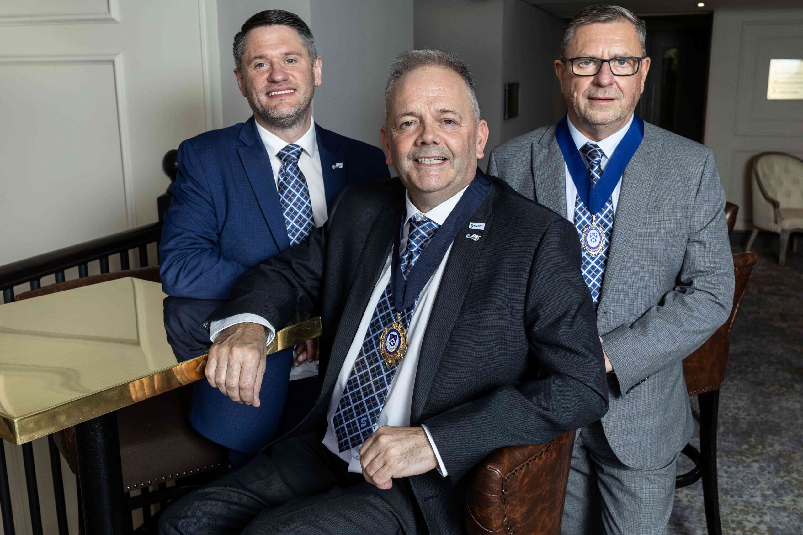 New SELECT Presidential Team Mike Campbell Darren Crockett and David Harris sat around a golden table inside the grounds of SELECT
