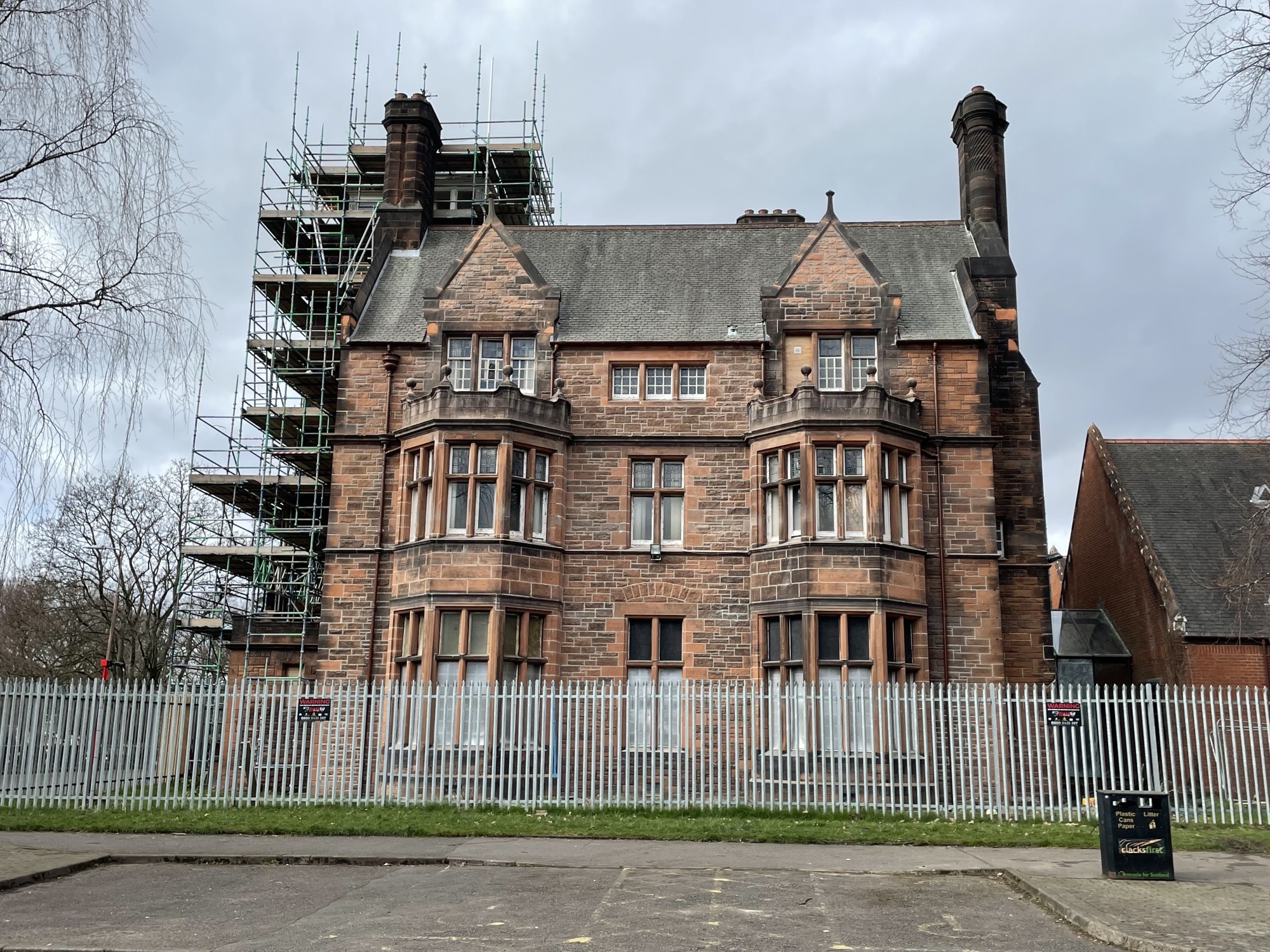 An image of Procast Greenfield House, surrounded by fencing with scaffolding shown at the side