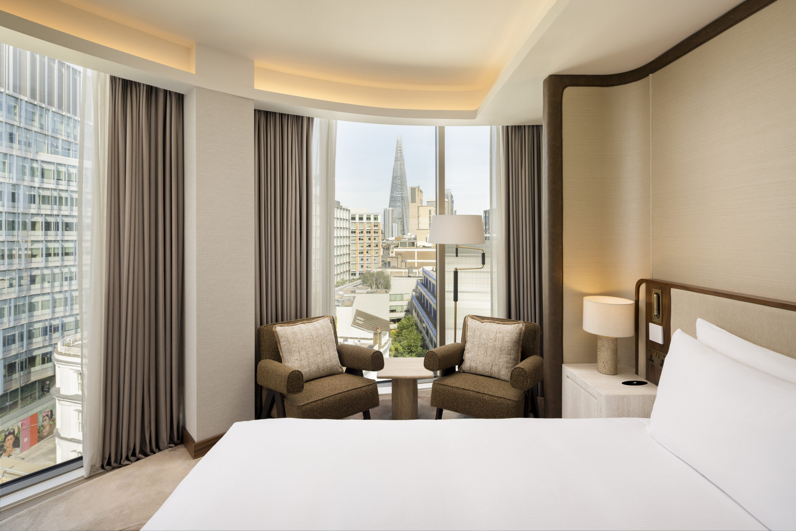 A long shot of the new bedroom as part of the new suite expansion of the Hilton London Bankside, showing a large double bed a large window floor to ceiling