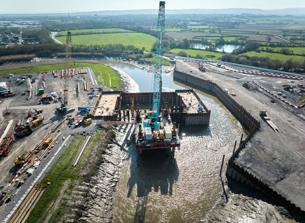 Birds eye view of stage 2 of the Bridgwater Tidal Barrier Scheme overlooking the River Parrett in the middle of green land and active building works