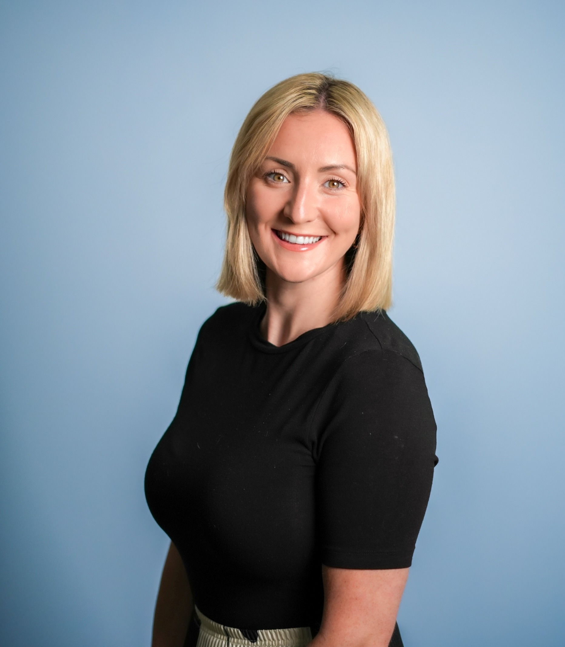 A professional photo of Danielle Keywood, Sector Lead for Local Authorities, with a blue gradient background