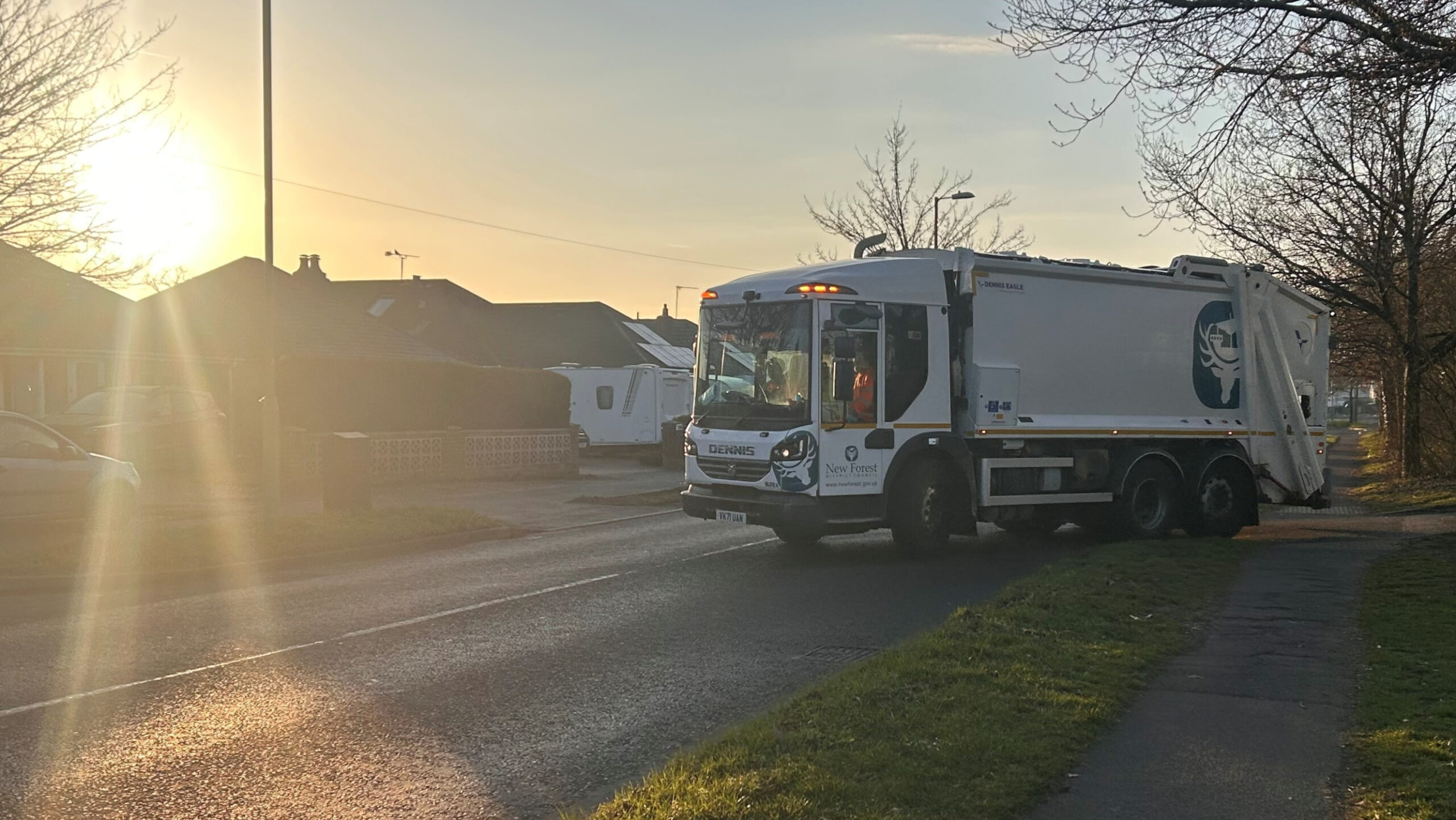 home-staging_01 NFDC Refuse truck driving down the road as the sun sets