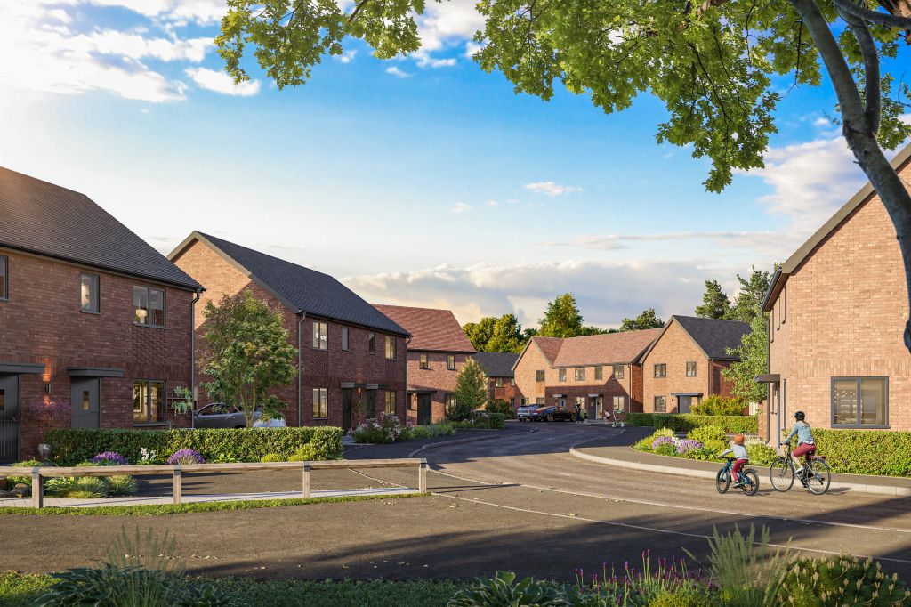 A long shot of a housing estate surrounded by birdsmouth fencing and greenery