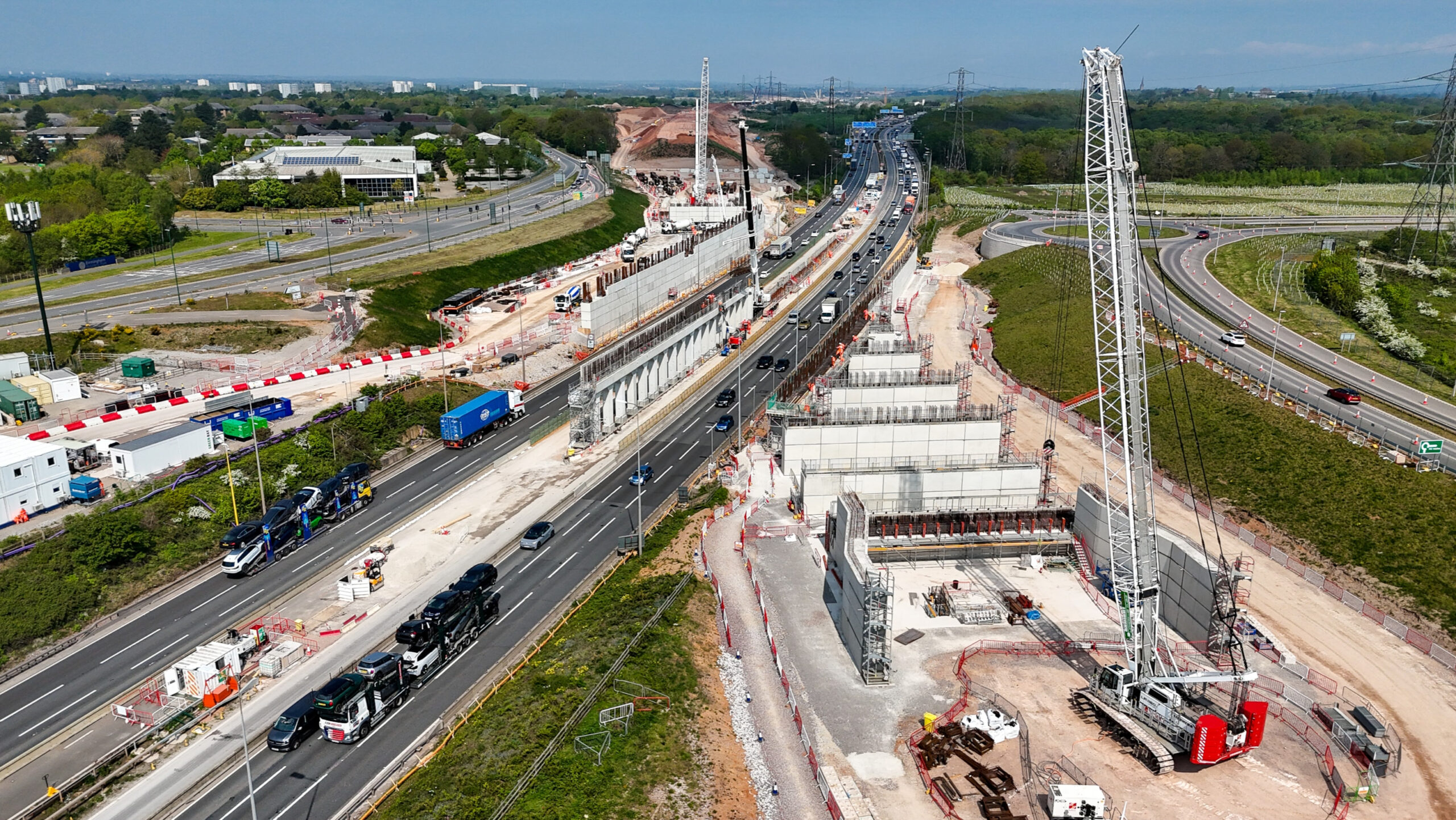 Birds eye view of a busy motorway with moving vehicles next to a building site