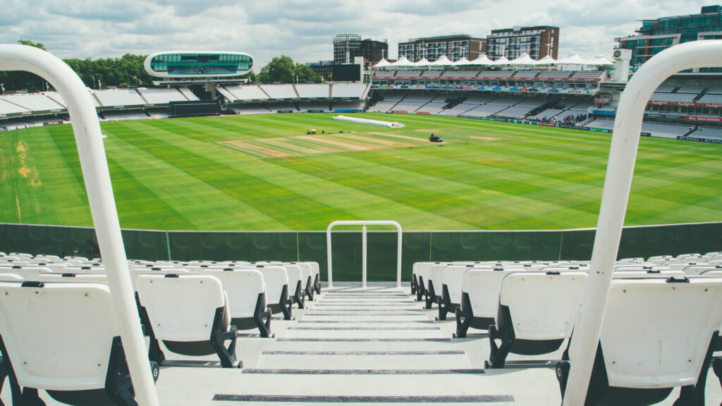 View across the empty seating and outfield at Lord’s Cricket Ground, with the distinctive Media Centre and surrounding stands in the background.
