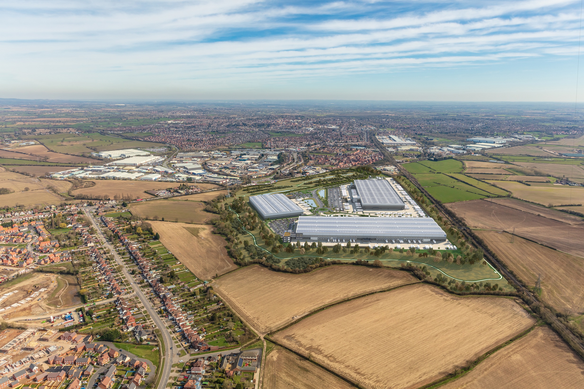 A birds eye view of rural land in the distance, houses and three separate on an industrial park