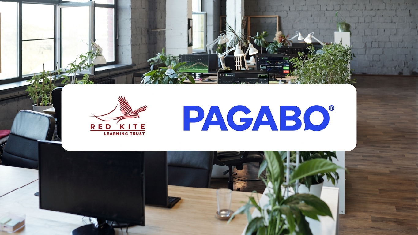 An empty office with a large, black l-shaped desk with the logo of PAGABO and Red Kite Learning Trust layered over the image